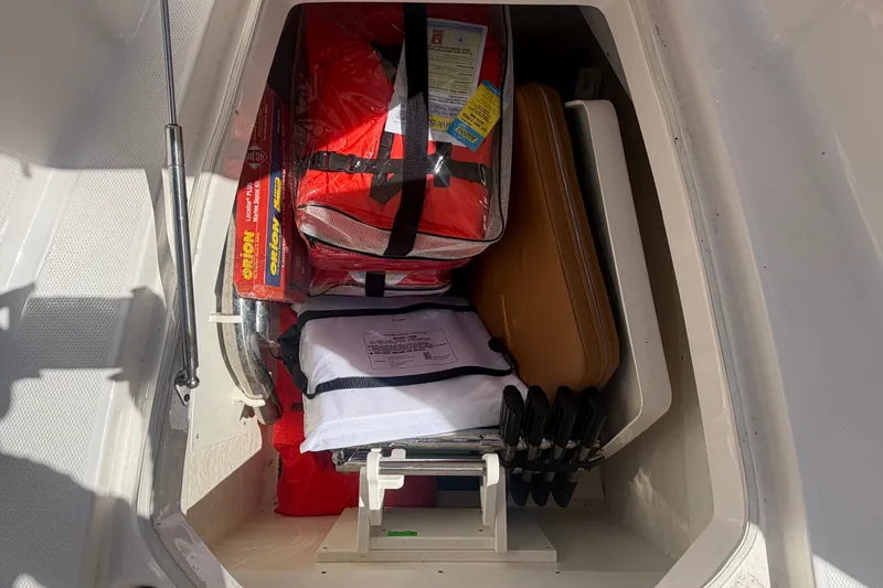 Slide: The Image of Storage compartment of 2025 Robalo R302 Center Console with safety gear and equipment. - 53