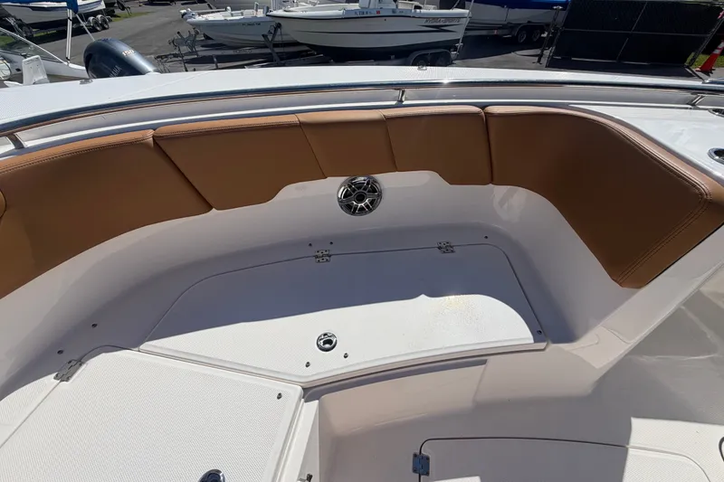 Slide: The Image of 2025 Robalo R302 Center Console boat with tan seating and storage compartments. - 49