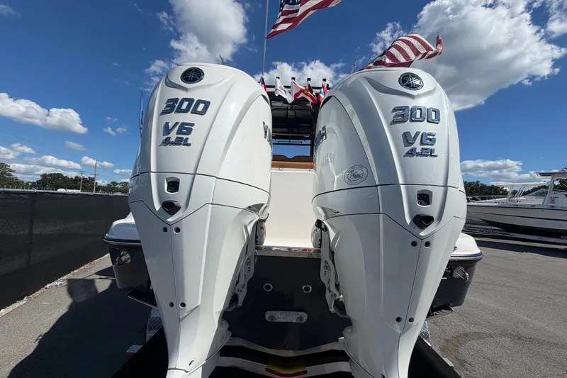 Slide: The Image of 2025 Robalo R302 Center Console with twin 300 V6 outboard engines, under a clear blue sky. - 4