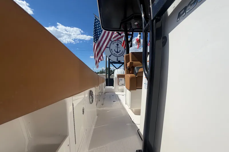 Slide: The Image of 2025 Robalo R302 Center Console boat interior with American flag and clear sky. - 70