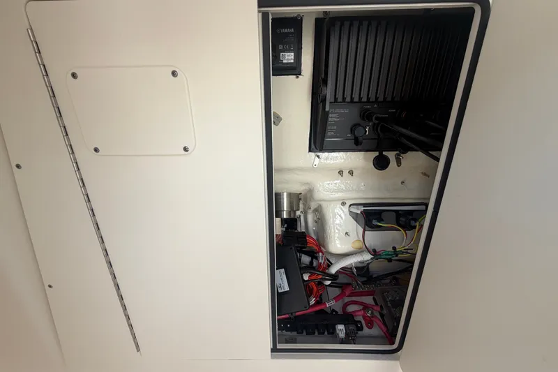 Slide: The Image of 2025 Robalo R302 Center Console electrical compartment with wiring and components. - 65