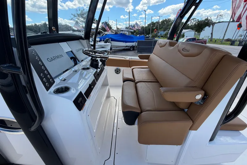 Slide: The Image of 2025 Robalo R302 Center Console boat interior with Garmin displays and tan seating. - 22