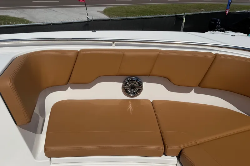 Slide: The Image of 2025 Robalo R302 Center Console boat with tan cushioned seating and speaker. - 42