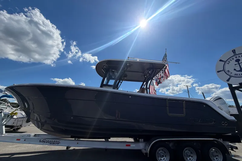 Slide: The Image of 2025 Robalo R302 Center Console boat on trailer under sunny sky. - 11