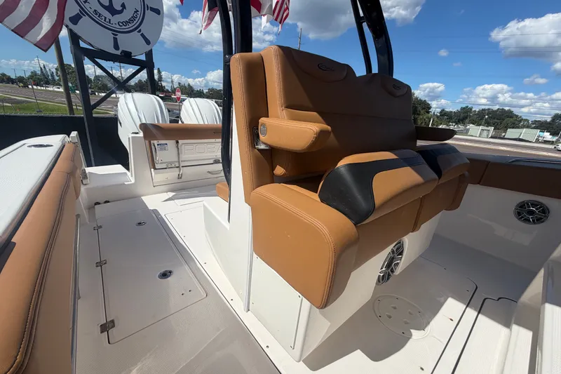 Slide: The Image of 2025 Robalo R302 Center Console boat interior with tan seating and dual engines. - 73