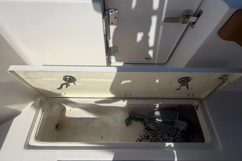 Slide: The Image of Open storage compartment on 2025 Robalo R302 Center Console boat with anchor and rope. - 78