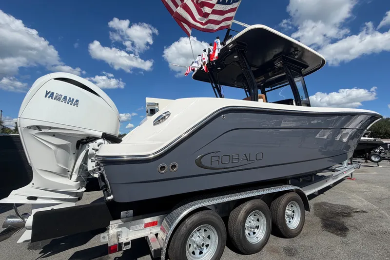 Slide: The Image of 2025 Robalo R302 Center Console boat with Yamaha engine on trailer under blue sky. - 3