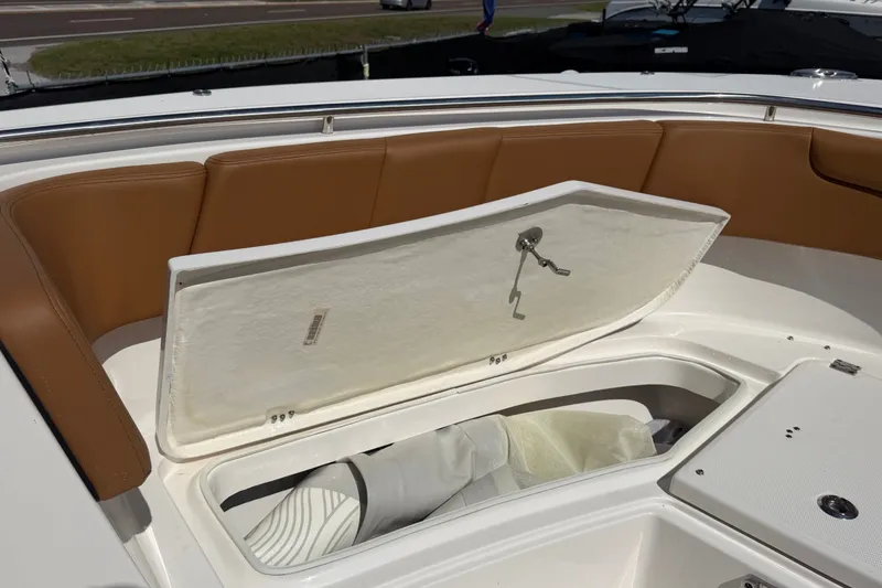 Slide: The Image of 2025 Robalo R302 Center Console boat with open storage compartment and cushioned seating. - 44