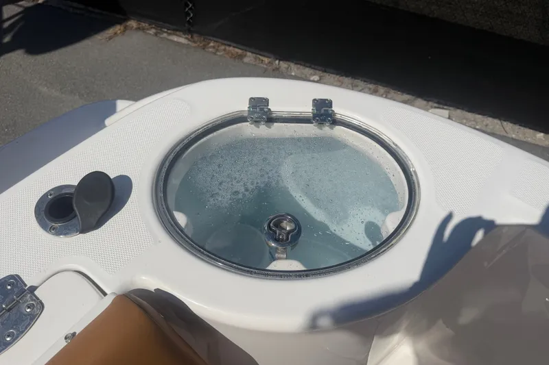 Slide: The Image of 2025 Robalo R302 Center Console livewell with water and secure lid. - 85