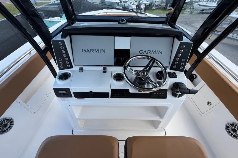 Slide: The Image of 2025 Robalo R302 Center Console helm with Garmin displays and modern controls. - 26