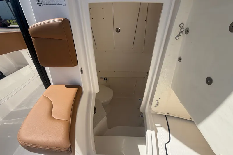 Slide: The Image of 2025 Robalo R302 Center Console interior with tan seating and storage compartments. - 61