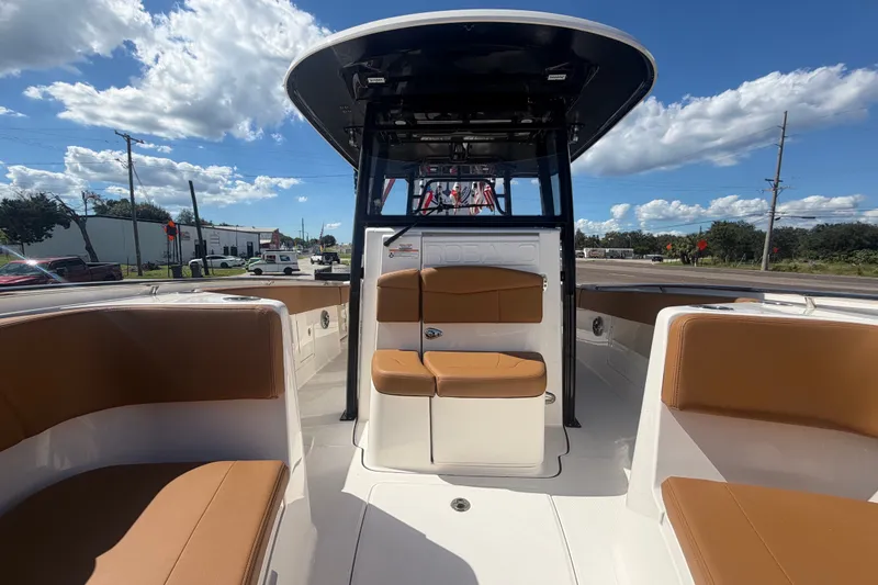 Slide: The Image of 2025 Robalo R302 Center Console boat with tan seating, under a clear blue sky. - 59
