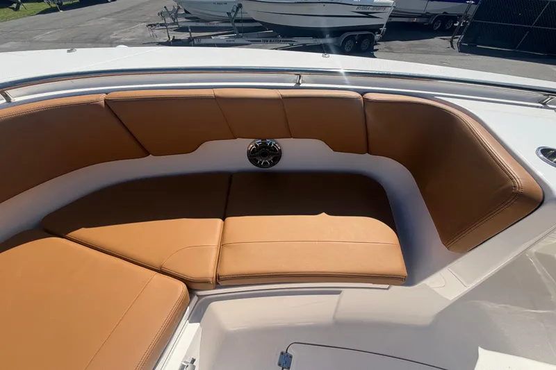 Slide: The Image of 2025 Robalo R302 Center Console boat with tan cushioned seating in the bow area. - 48