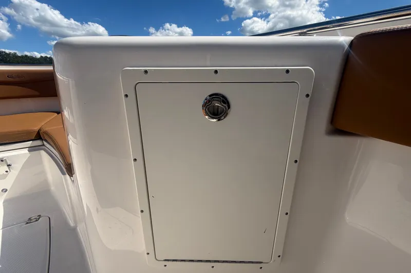 Slide: The Image of 2025 Robalo R302 Center Console boat interior with storage compartment under clear blue sky. - 67