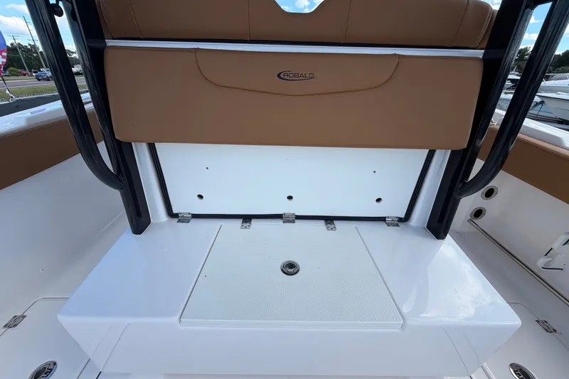 Slide: The Image of 2025 Robalo R302 Center Console boat interior with tan seating and storage compartment. - 19