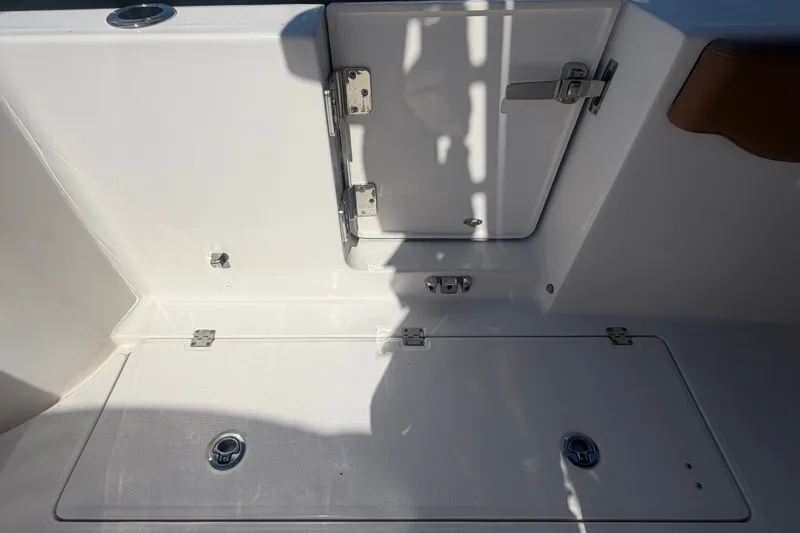 Slide: The Image of 2025 Robalo R302 Center Console boat storage compartments and hatch detail. - 77