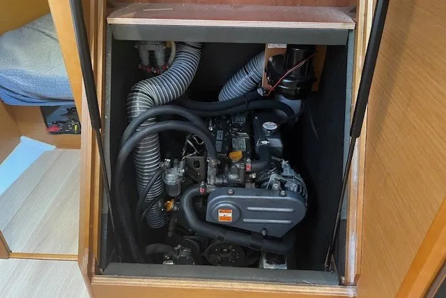 Slide: The Image of Engine compartment of 2017 Jeanneau Sun Odyssey 389 sailboat, showcasing mechanical components and hoses. - 14