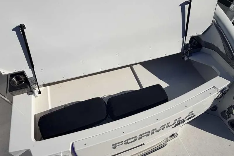 Slide: The Image of 2023 Formula 350 Crossover Bowrider I/O storage compartment with open hatch and cushions. - 6