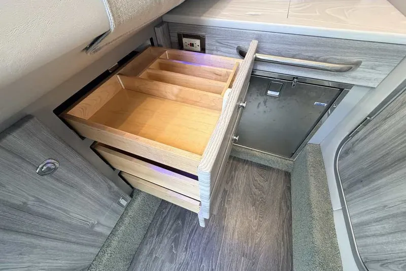 Slide: The Image of 2023 Formula 350 Crossover Bowrider I/O interior with open wooden drawer and stainless steel cabinet. - 66