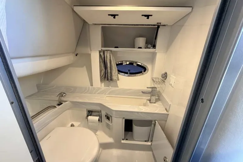 Slide: The Image of Modern bathroom in 2023 Formula 350 Crossover Bowrider I/O boat, featuring sleek fixtures and storage. - 64