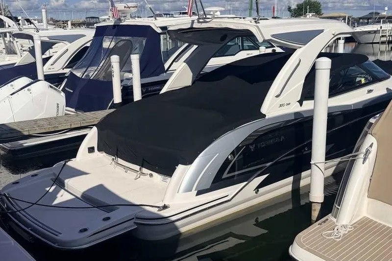 Slide: The Image of 2023 Formula 350 Crossover Bowrider I/O docked at marina, covered and ready for adventure. - 1