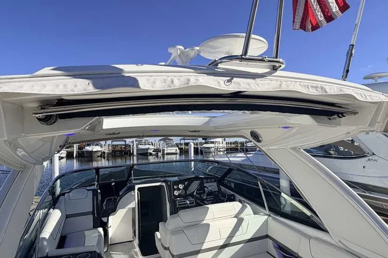 Slide: The Image of 2023 Formula 350 Crossover Bowrider I/O interior with open sunroof, docked at marina. - 8
