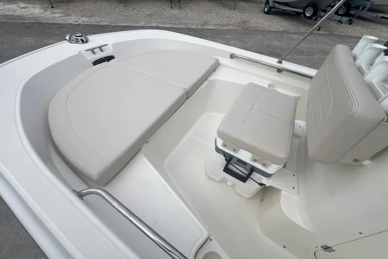 Slide: The Image of 2027 Boston Whaler 150 Montauk boat interior with cushioned seating and storage. - 10