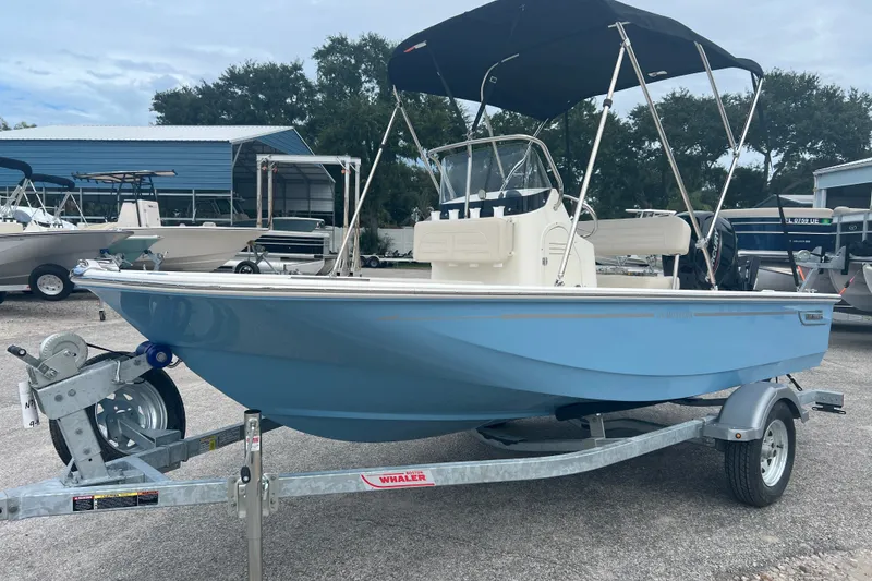 Slide: The Image of 2027 Boston Whaler 150 Montauk boat on trailer, featuring a sleek blue hull and canopy. - 4