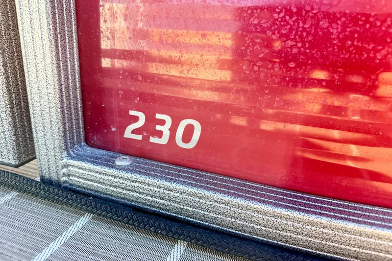 Slide: The Image of Close-up of 2021 Manitou 23 Oasis boat with '230' marking on red surface. - 16
