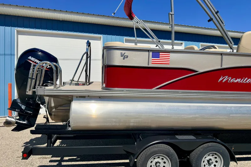 Slide: The Image of 2021 Manitou 23 Oasis pontoon boat with Mercury engine on trailer, American flag decal. - 9