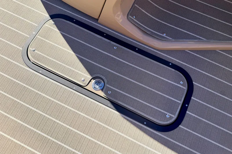 Slide: The Image of 2021 Manitou 23 Oasis boat deck with striped flooring and access hatch. - 59