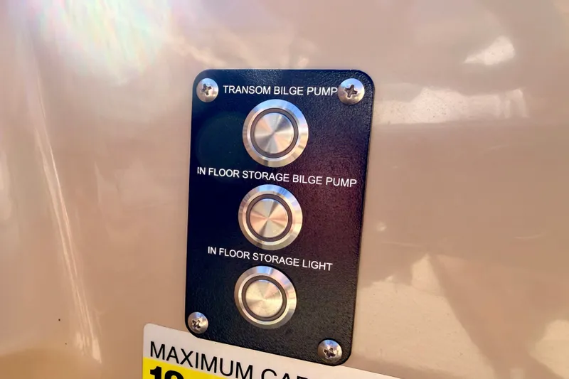 Slide: The Image of Control panel on 2021 Manitou 23 Oasis with bilge pump and storage light switches. - 52