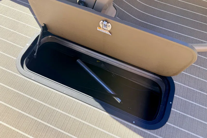 Slide: The Image of Open storage compartment on 2021 Manitou 23 Oasis boat deck. - 60