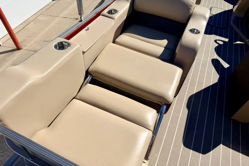 Slide: The Image of 2021 Manitou 23 Oasis boat interior with beige seating and cup holders. - 38