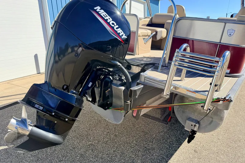 Slide: The Image of 2021 Manitou 23 Oasis pontoon boat with Mercury outboard motor and swim ladder. - 24