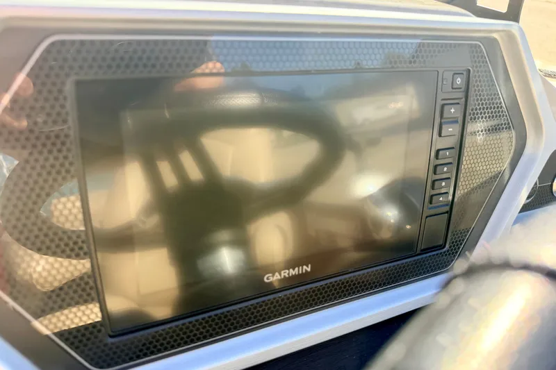 Slide: The Image of Garmin display on 2021 Manitou 23 Oasis boat dashboard, featuring control buttons. - 48