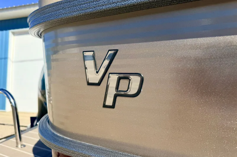 Slide: The Image of Close-up of 2021 Manitou 23 Oasis boat with VP logo in sunlight. - 23