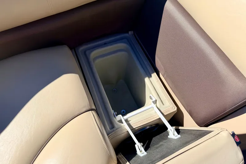 Slide: The Image of Storage compartment in 2021 Manitou 23 Oasis boat with beige and brown seating. - 70
