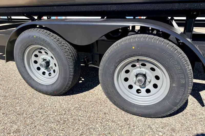 Slide: The Image of Trailer wheels of a 2021 Manitou 23 Oasis on a sunny day. - 115