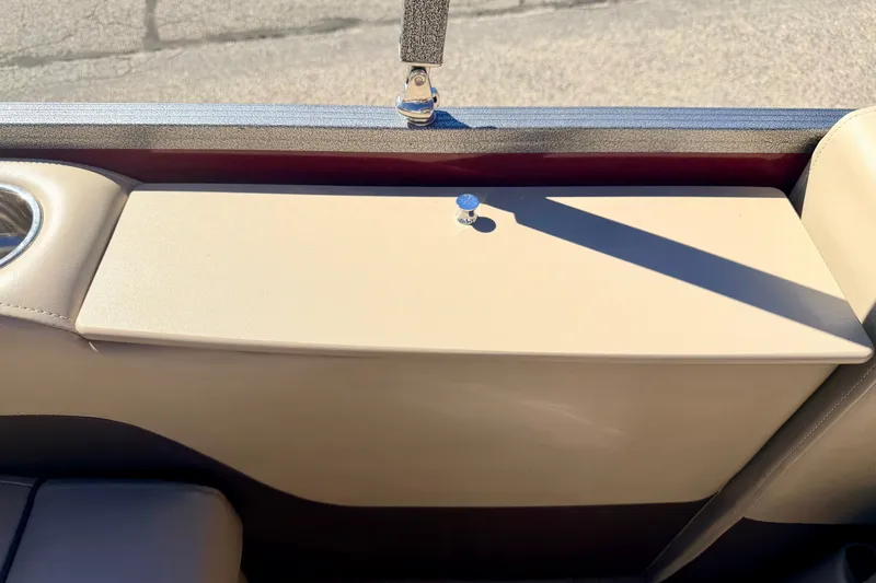 Slide: The Image of Interior detail of 2021 Manitou 23 Oasis boat, featuring beige upholstery and cup holder. - 36