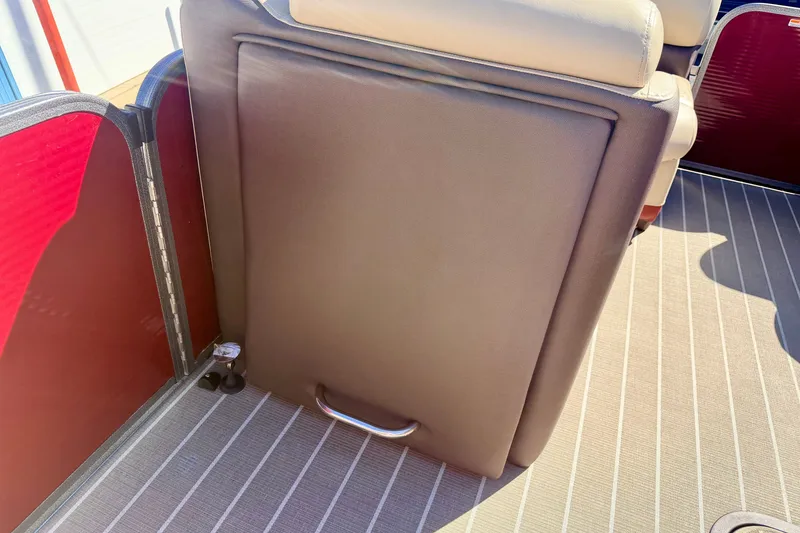 Slide: The Image of 2021 Manitou 23 Oasis boat interior with beige seating and striped flooring. - 64