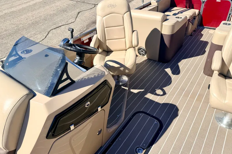 Slide: The Image of Interior of 2021 Manitou 23 Oasis boat with beige seating and steering console. - 78