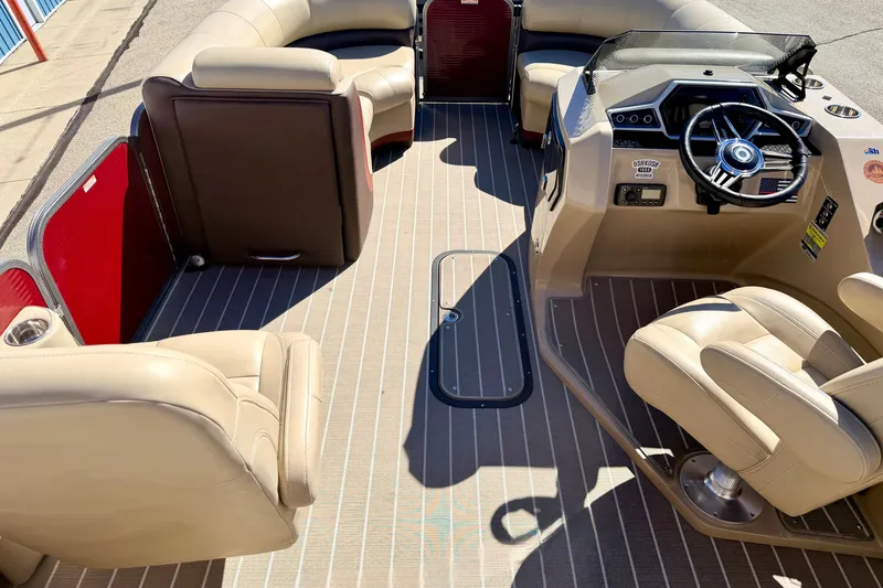Slide: The Image of Interior view of 2021 Manitou 23 Oasis pontoon boat with beige seating and steering console. - 79