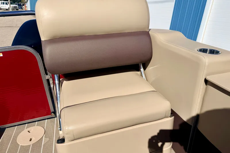 Slide: The Image of 2021 Manitou 23 Oasis boat seat with beige and brown upholstery, cup holder, and red panel. - 39