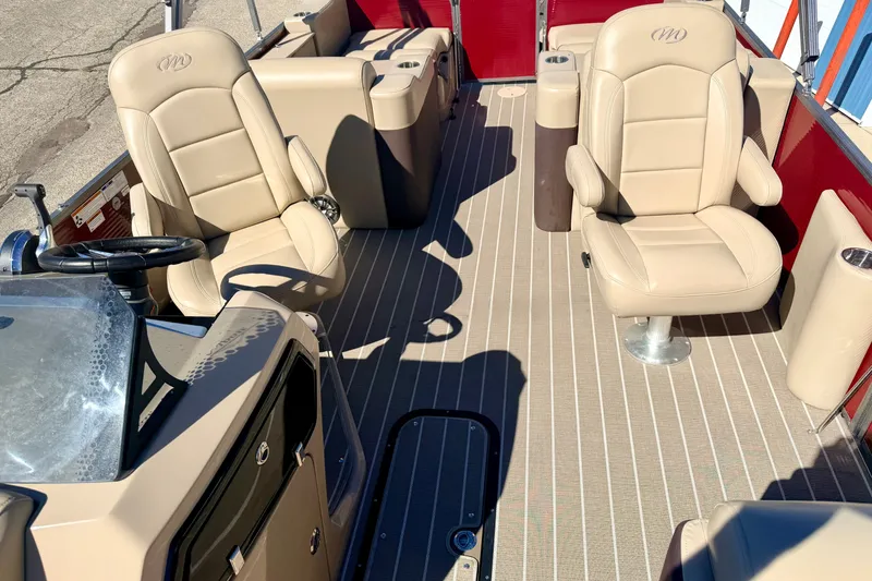 Slide: The Image of 2021 Manitou 23 Oasis boat interior with beige seating and steering console. - 77