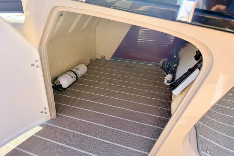Slide: The Image of Storage compartment of 2021 Manitou 23 Oasis boat with fire extinguisher and wiring. - 58