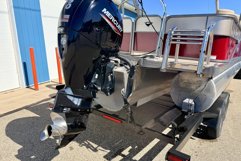 Slide: The Image of 2021 Manitou 23 Oasis pontoon boat with Mercury outboard motor, parked on trailer. - 105
