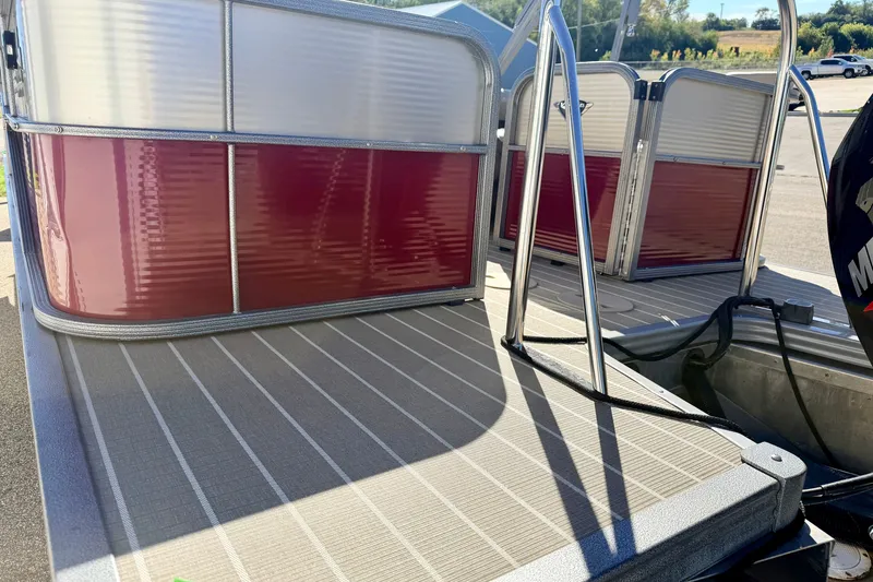 Slide: The Image of 2021 Manitou 23 Oasis pontoon boat with red and silver exterior, docked on a sunny day. - 29