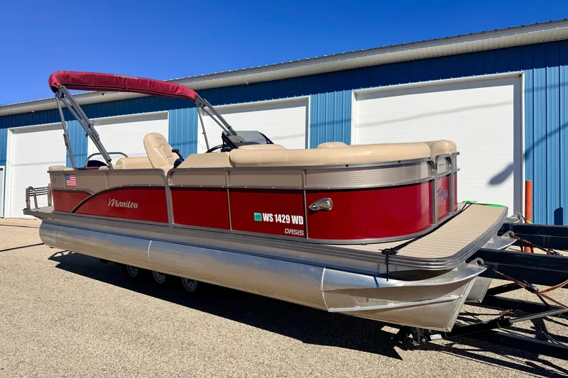 The Image of 2021 Manitou 23 Oasis pontoon boat with red exterior, parked outdoors. - 0