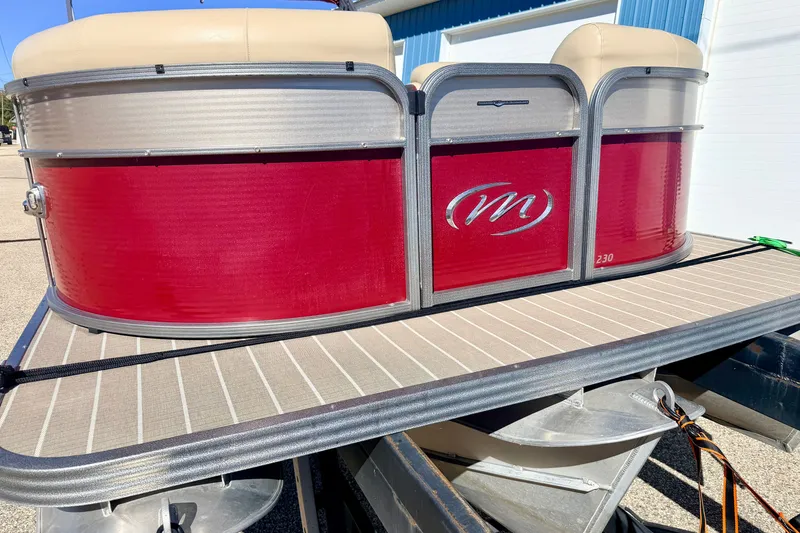 Slide: The Image of 2021 Manitou 23 Oasis pontoon boat with red exterior and beige seating. - 20